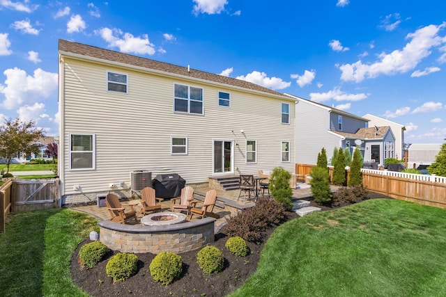 rear view of property featuring a yard, a patio, fence, and an outdoor fire pit