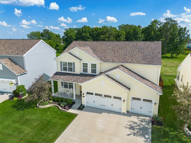 traditional-style home featuring a shingled roof, a porch, concrete driveway, a front yard, and an attached garage