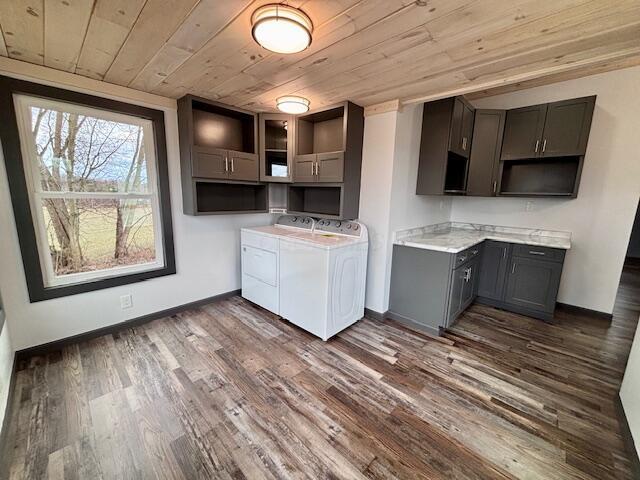 kitchen with baseboards, separate washer and dryer, gray cabinetry, dark wood-type flooring, and wooden ceiling