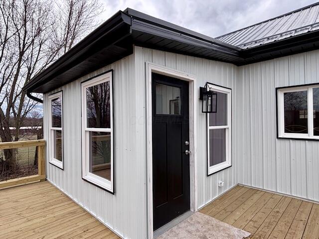 doorway to property with a wooden deck and metal roof