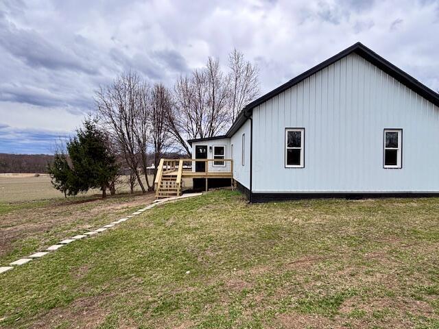 view of home's exterior with a yard and a deck