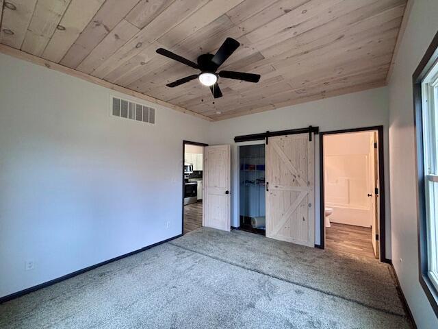 unfurnished bedroom featuring visible vents, carpet flooring, wooden ceiling, and baseboards