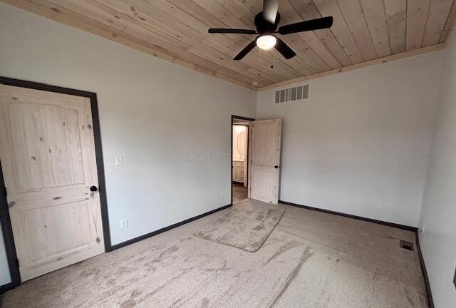 carpeted spare room featuring visible vents, wooden ceiling, baseboards, and ceiling fan