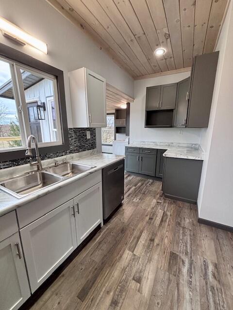 kitchen with dark wood finished floors, wood ceiling, black dishwasher, decorative backsplash, and a sink