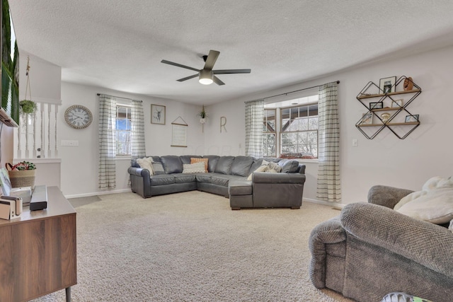 carpeted living room featuring a textured ceiling, baseboards, and ceiling fan