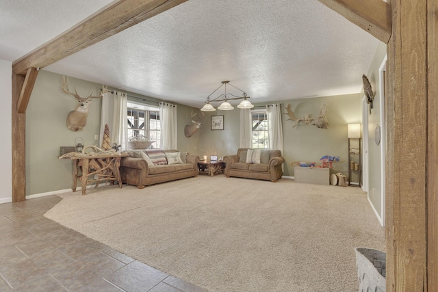 living area featuring carpet flooring, beamed ceiling, and a textured ceiling