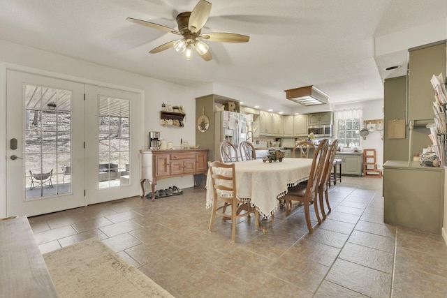 dining space with stone tile floors and a ceiling fan