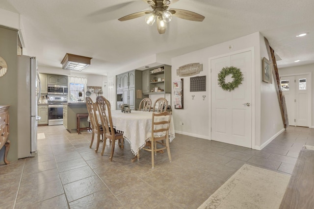 dining room with tile patterned floors, baseboards, and ceiling fan