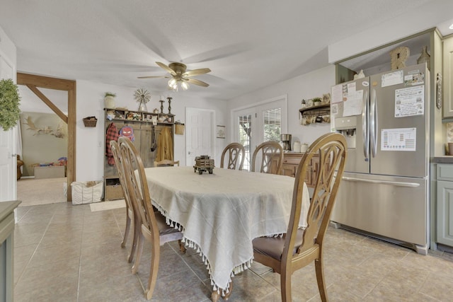 dining room with a textured ceiling, light tile patterned flooring, and ceiling fan