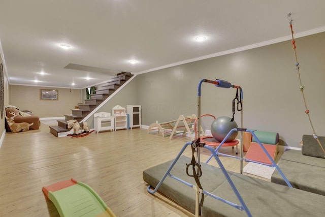 workout room with wood finished floors, baseboards, and ornamental molding