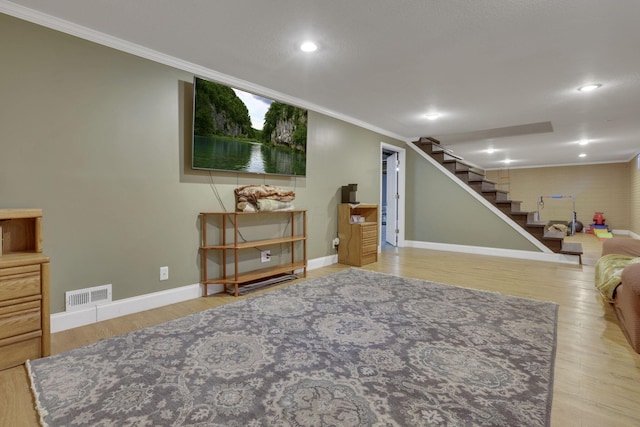 interior space featuring visible vents, wood finished floors, ornamental molding, and stairs