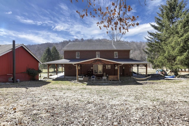 rear view of house featuring brick siding and a patio