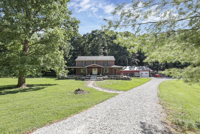 view of front of home featuring a front yard, an outdoor structure, an attached garage, and driveway