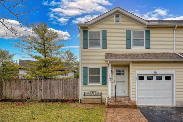 view of front of house featuring entry steps, driveway, a garage, and fence