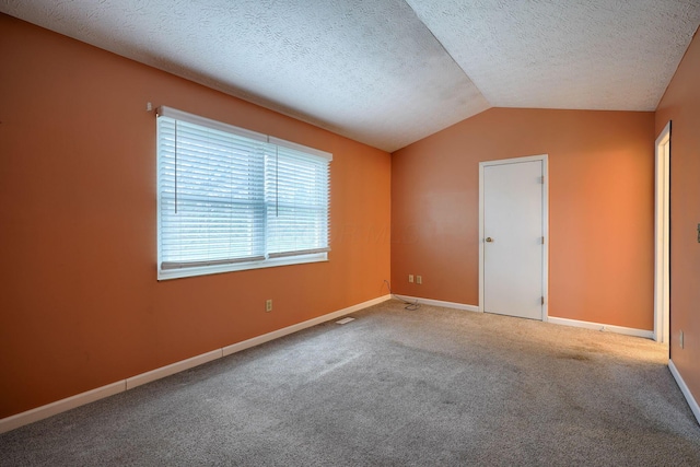 unfurnished room featuring baseboards, carpet floors, a textured ceiling, and vaulted ceiling