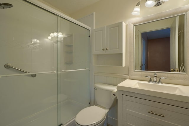 bathroom with vanity, toilet, and a stall shower