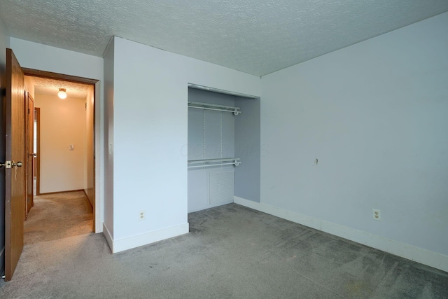 unfurnished bedroom with baseboards, carpet floors, and a textured ceiling