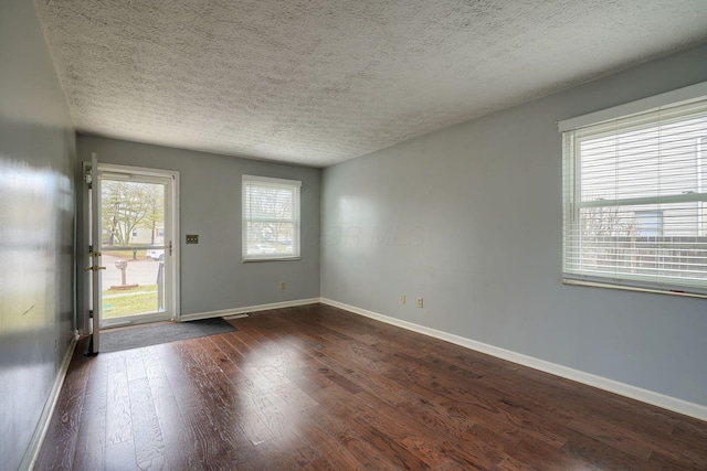 entrance foyer featuring baseboards, a textured ceiling, and dark wood-style floors