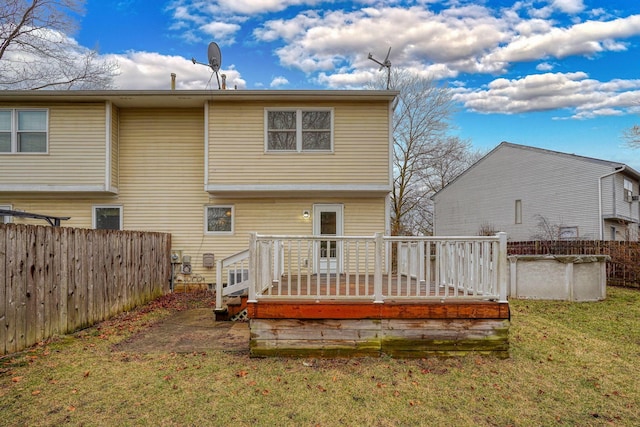 rear view of property featuring a fenced in pool, a lawn, a deck, and fence