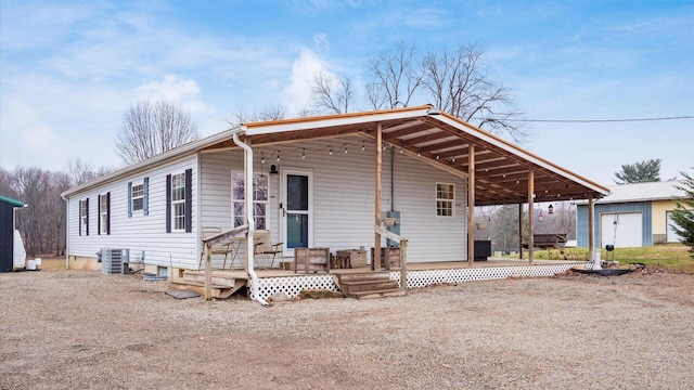 view of front of property featuring an outbuilding, central air condition unit, and covered porch