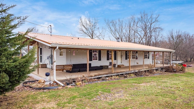 view of front of house featuring a front yard, covered porch, and metal roof