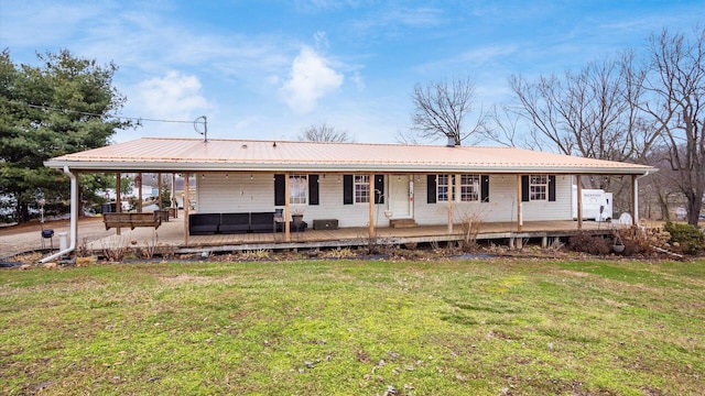 view of front of property featuring metal roof, a porch, and a front lawn