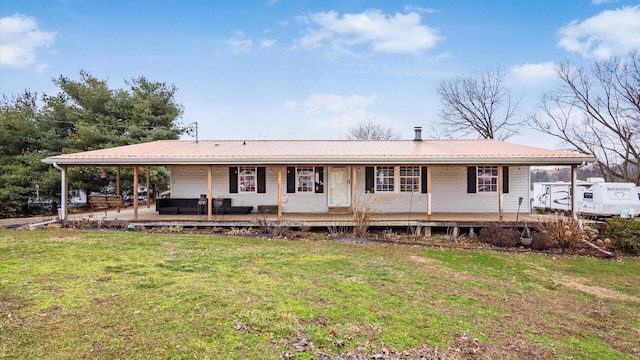 view of front of house featuring a front yard, metal roof, covered porch, and an outdoor hangout area