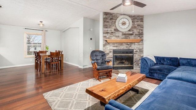 living area featuring a ceiling fan, lofted ceiling, wood finished floors, and baseboards