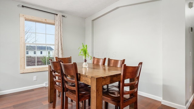 dining area featuring baseboards and wood finished floors