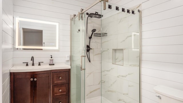 bathroom with toilet, a stall shower, and vanity