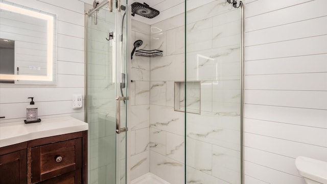 full bath featuring toilet, a stall shower, and vanity