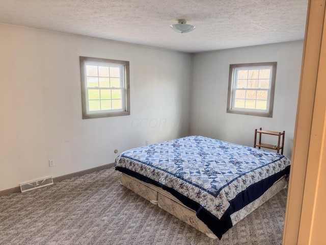 bedroom featuring visible vents, carpet flooring, baseboards, and multiple windows