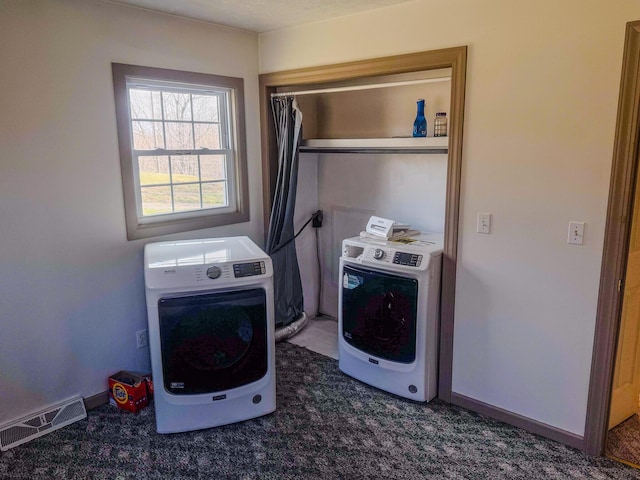 laundry area featuring heating unit, baseboards, visible vents, laundry area, and washer / dryer