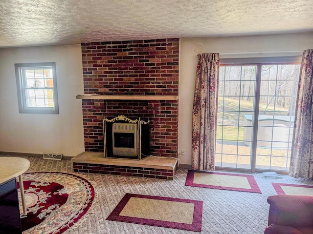 carpeted living room featuring visible vents and a textured ceiling