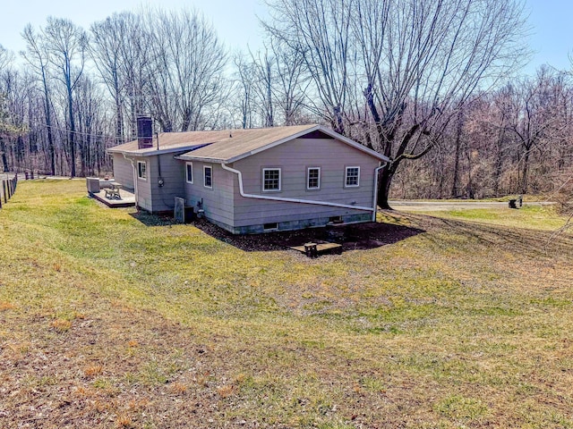 exterior space featuring central air condition unit, a lawn, and a chimney