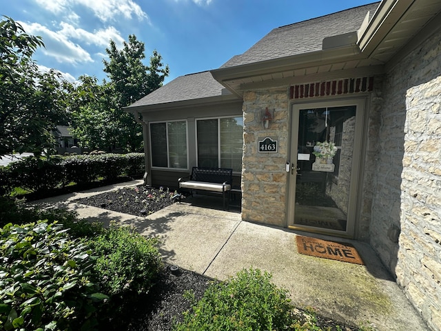 4163 Windbud Dr, New Albany, OH 43054 - view of exterior entry featuring stone siding and a patio