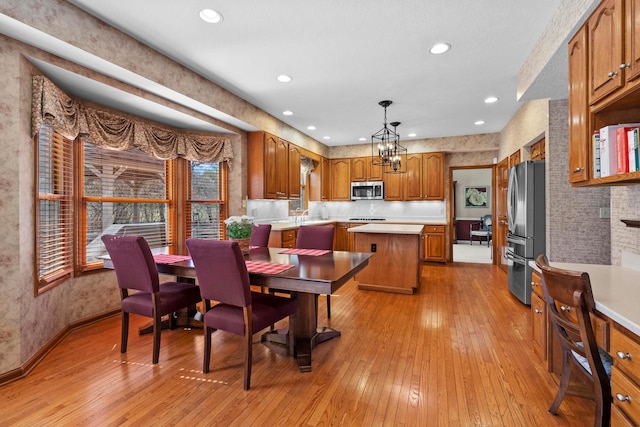 dining space featuring recessed lighting, an inviting chandelier, baseboards, and light wood-style floors