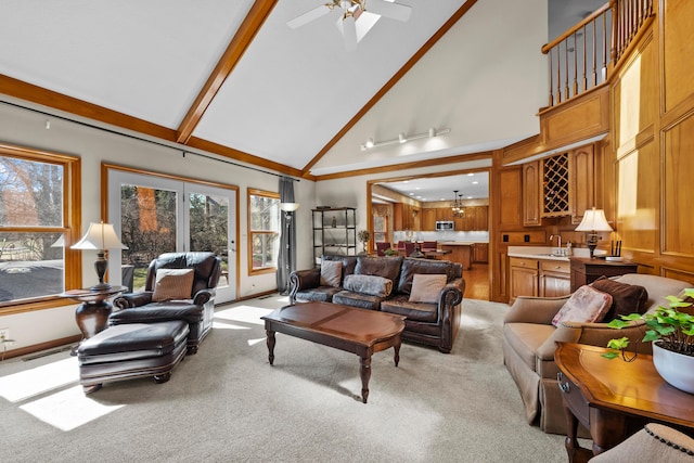 living area with indoor wet bar, light colored carpet, ceiling fan, and high vaulted ceiling