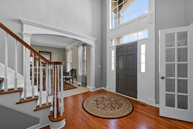 entrance foyer with hardwood / wood-style flooring, plenty of natural light, visible vents, and arched walkways