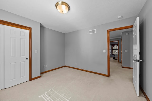 empty room with a textured ceiling, carpet, visible vents, and baseboards