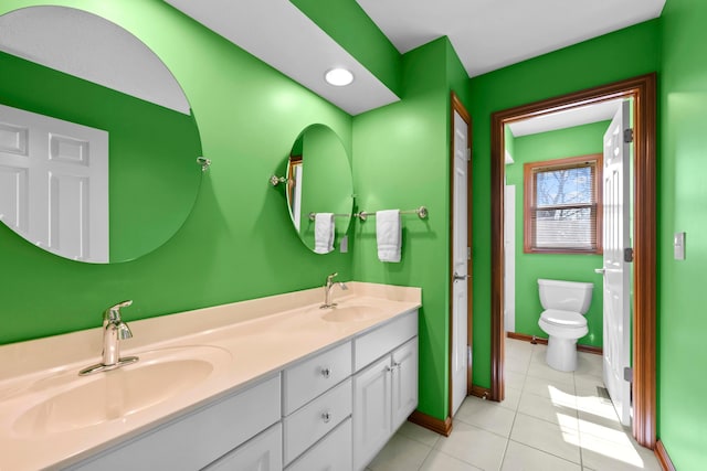 full bath featuring double vanity, tile patterned flooring, toilet, and a sink