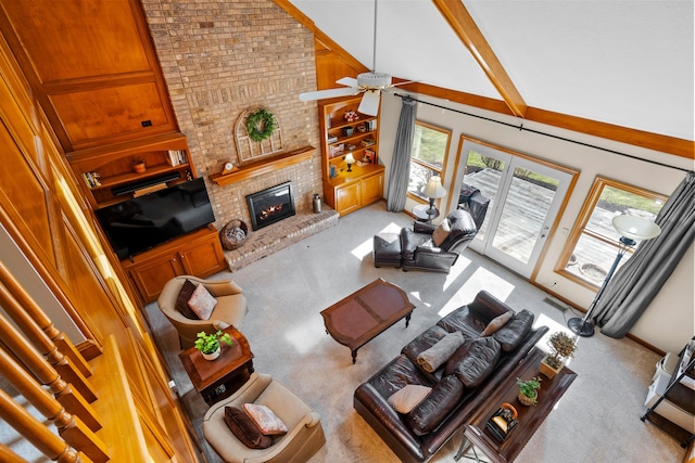 carpeted living area featuring visible vents, a fireplace, high vaulted ceiling, and ceiling fan