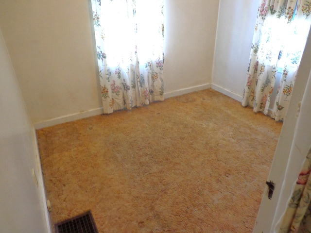 unfurnished room featuring visible vents, baseboards, and carpet floors