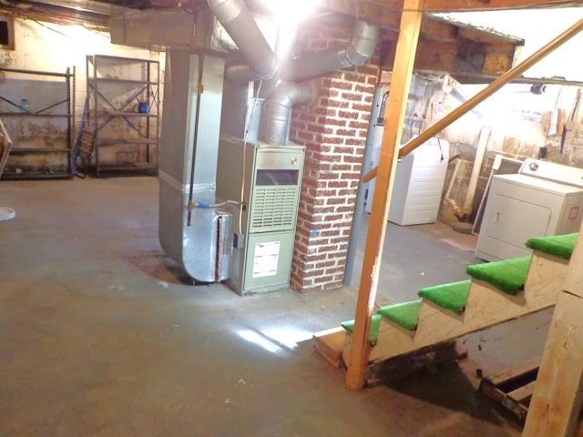 unfinished below grade area featuring heating unit and washer and clothes dryer