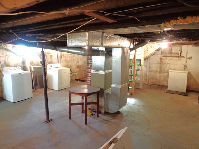 unfinished below grade area featuring heating unit and independent washer and dryer