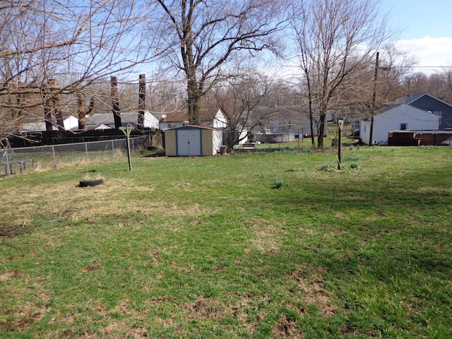 view of yard with fence, an outdoor structure, and a shed