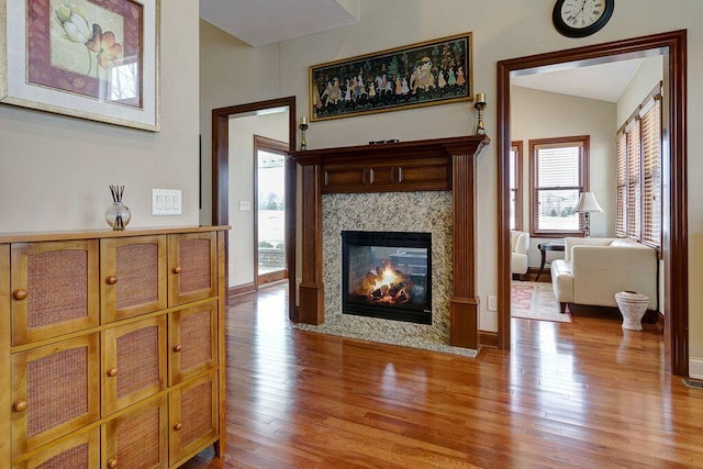 6884 Ballantrae Pl, Dublin, OH 43016 - living area featuring baseboards, lofted ceiling, a fireplace, and hardwood / wood-style flooring