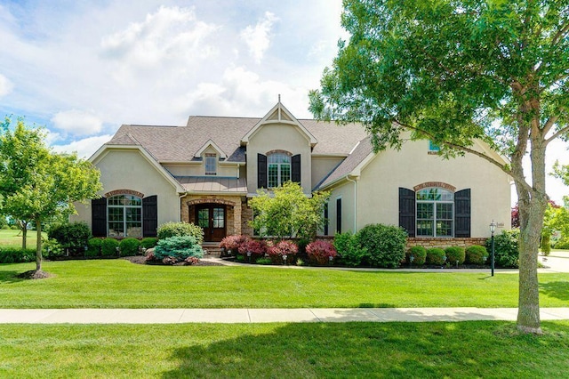 6884 Ballantrae Pl, Dublin, OH 43016 - view of front facade with roof with shingles, stucco siding, a front lawn, french doors, and stone siding