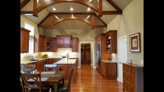 6884 Ballantrae Pl, Dublin, OH 43016 - kitchen with decorative backsplash, glass insert cabinets, light wood finished floors, and a center island