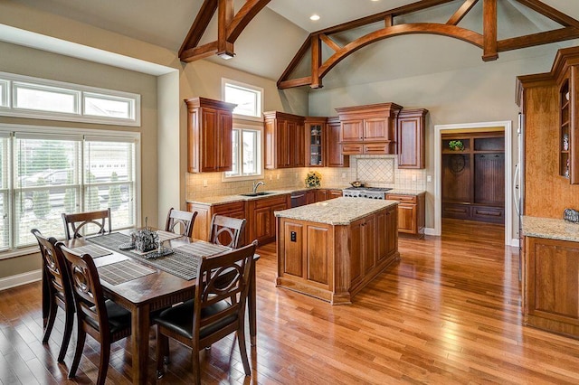 6884 Ballantrae Pl, Dublin, OH 43016 - dining room featuring baseboards, high vaulted ceiling, and light wood finished floors